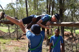 Students climbing over log in Adventure Race